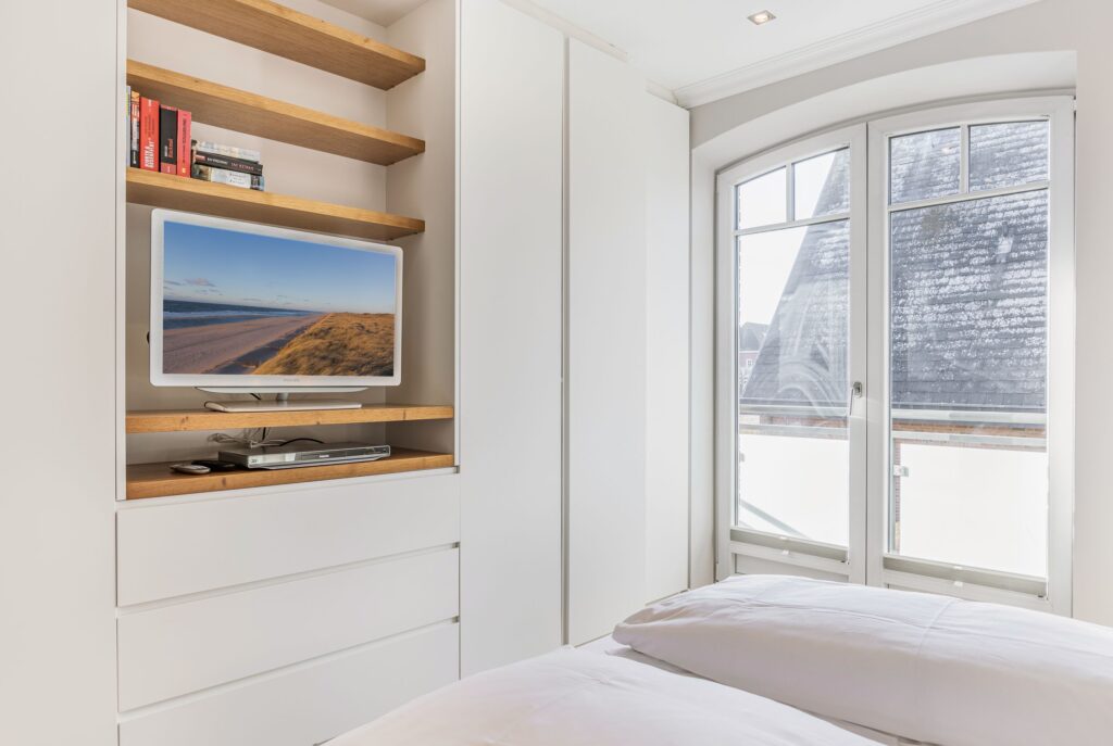 Schlafzimmer mit TV in Ferienwohnung Wenningstedt