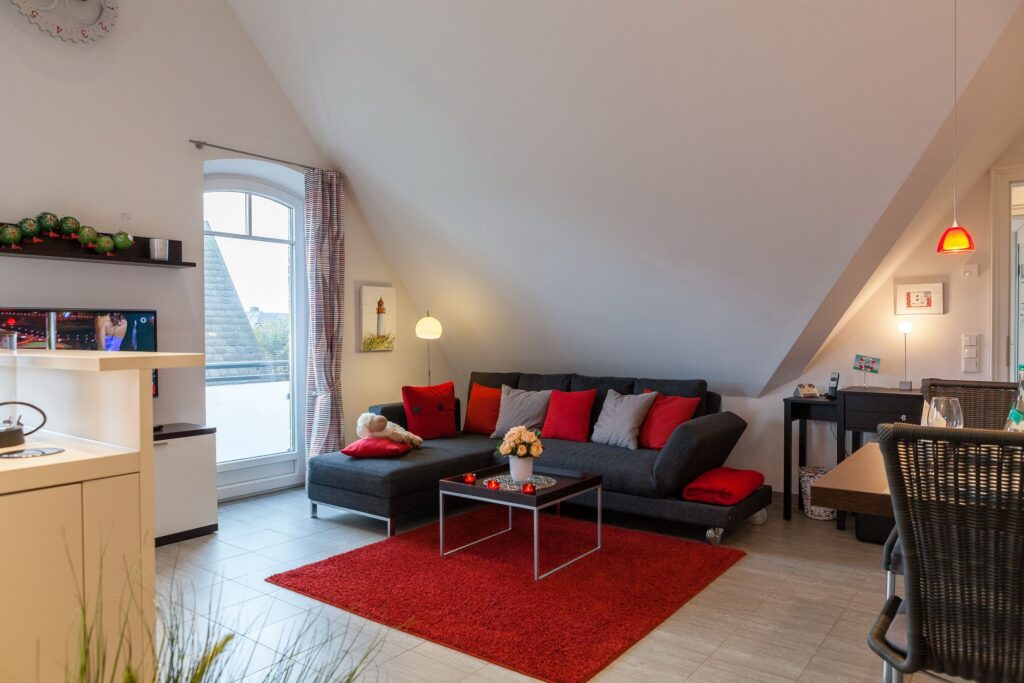 Wohnzimmer mit rotem Teppich in Ferienwohnung Wenningstedt