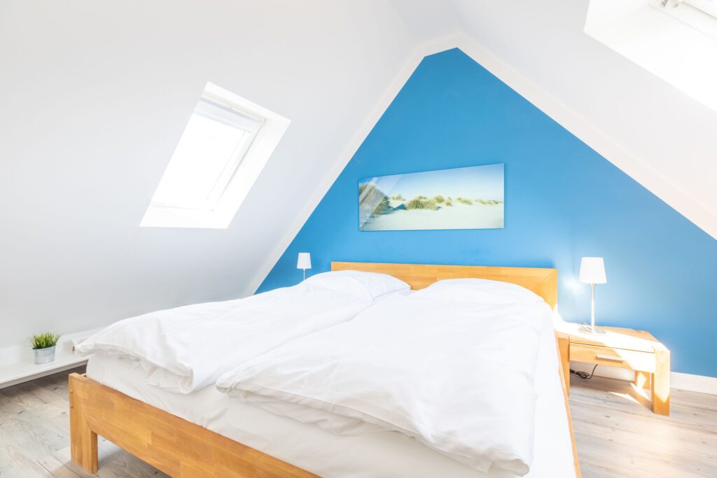 Schlafzimmer mit blauer Wand in Ferienwohnung Wenningstedt