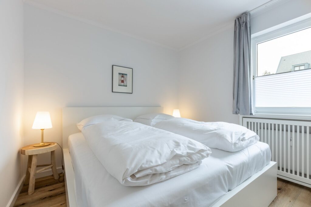 Doppelbett im Schlafzimmer in Ferienwohnung Wenningstedt