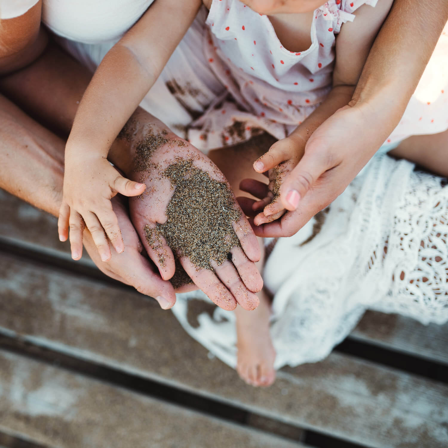 Eltern und Kind spielen mit Sand