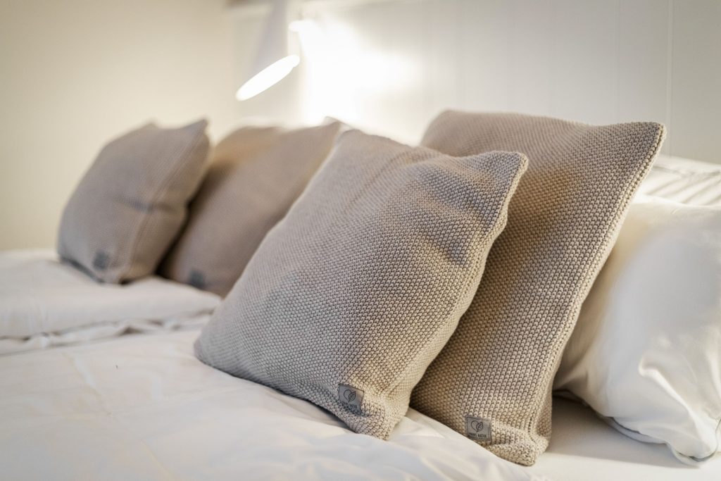 Gemütliches Doppelbett mit vielen Kissen in Ferienwohnung auf Sylt
