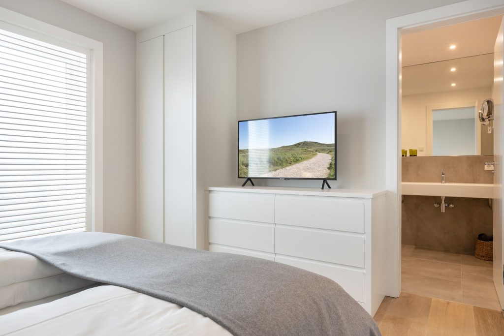 Schlafzimmer mit Einblick in ein Badezimmer einer Ferienwohnung auf Sylt