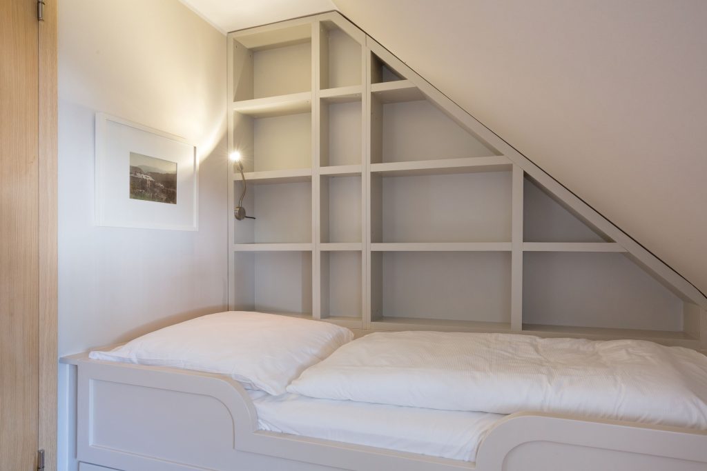 Schlafzimmer mit einem Einzelbett in einer Ferienwohnung auf Sylt.