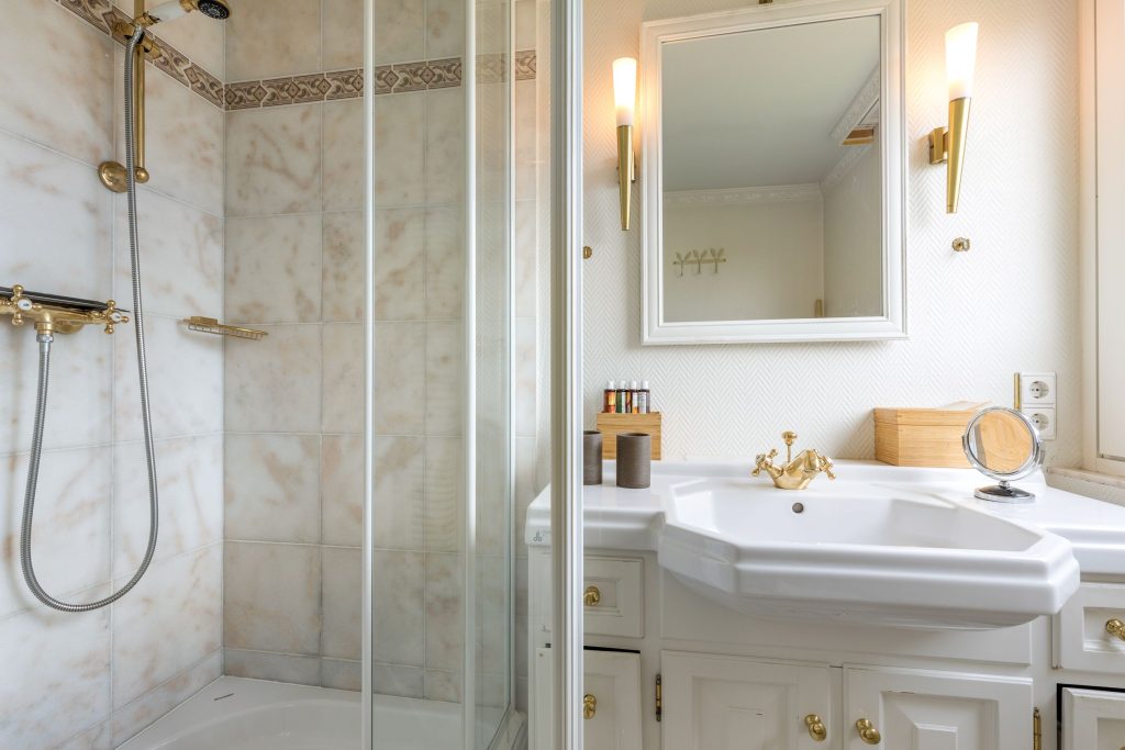 Ein Badezimmer mit goldenen Akzenten in einer Ferienwohnung auf Sylt