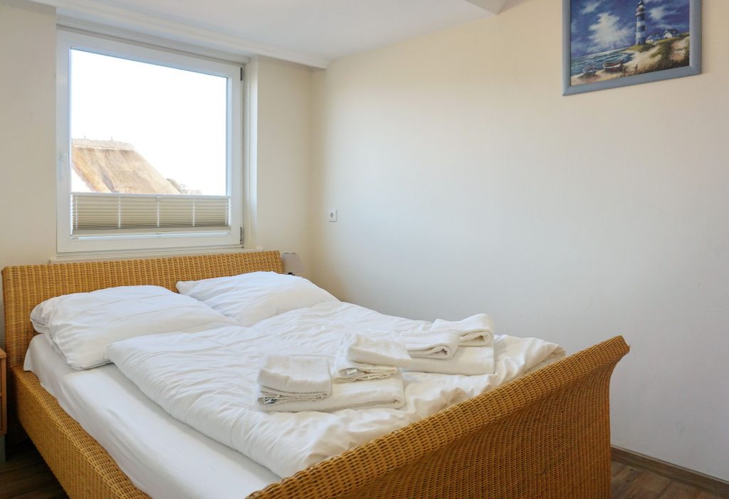Bett mit Fenster in Sylter Ferienwohnung