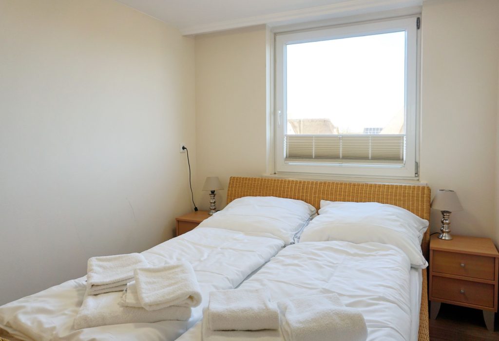 Bett mit Fenster in Sylter Ferienwohnung