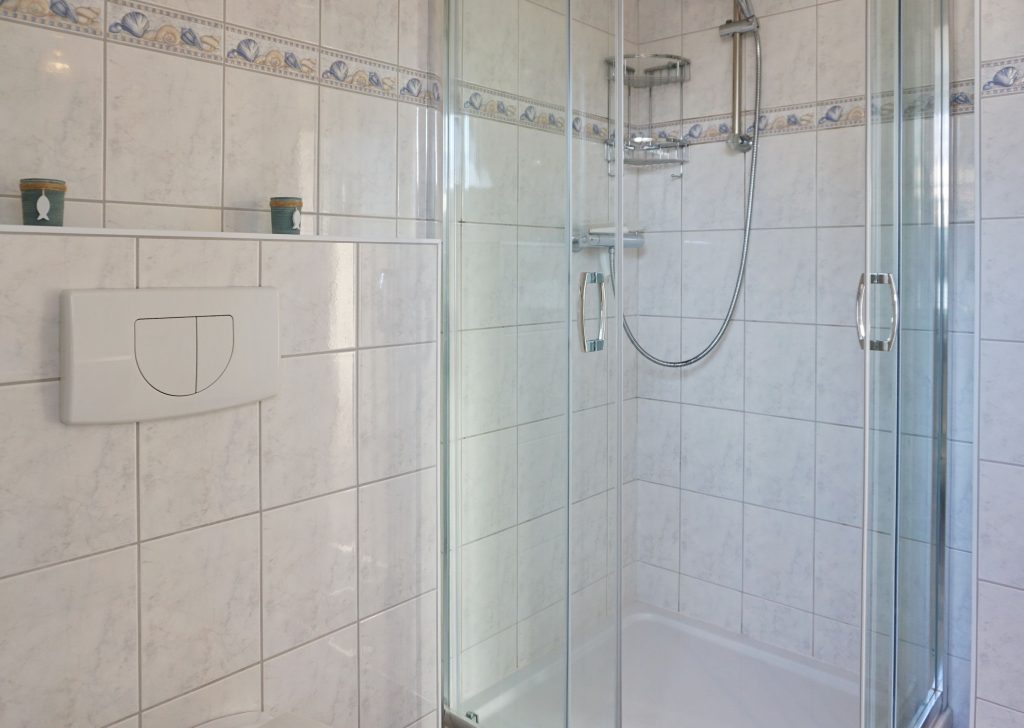 Gefliestes Badezimmer mit Dusche in Sylter Ferienhaus
