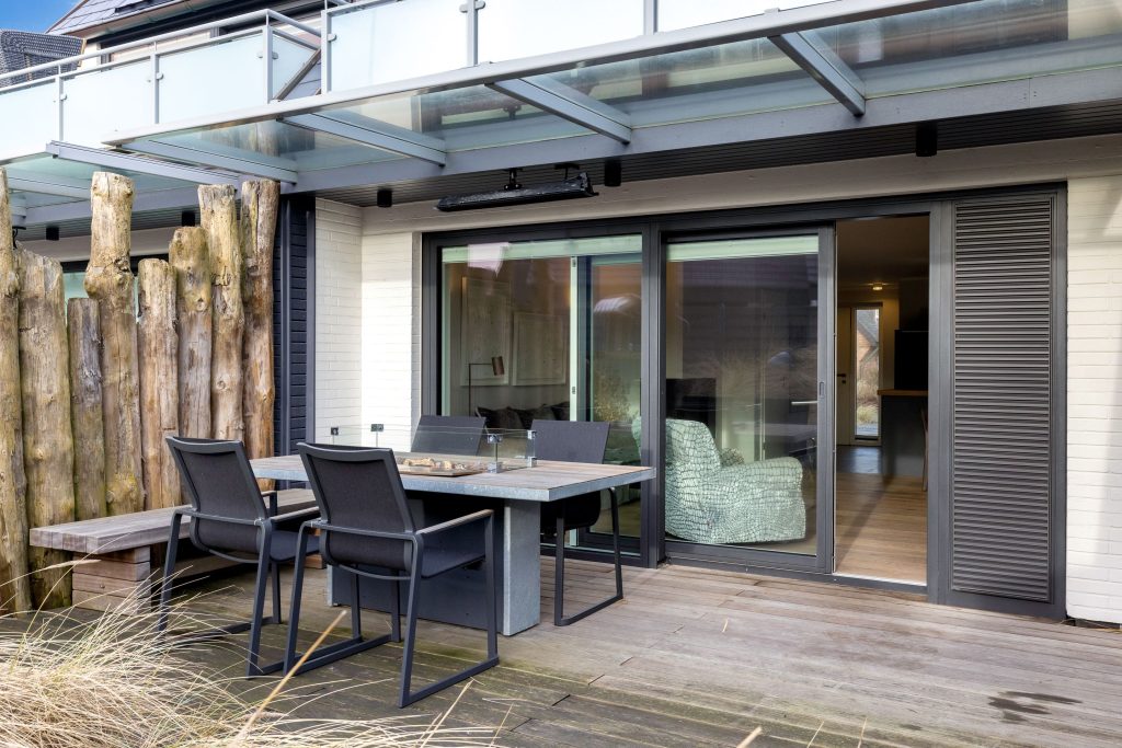 Blick auf Esstisch und Wohnbereich von außen in Ferienwohnung auf Sylt