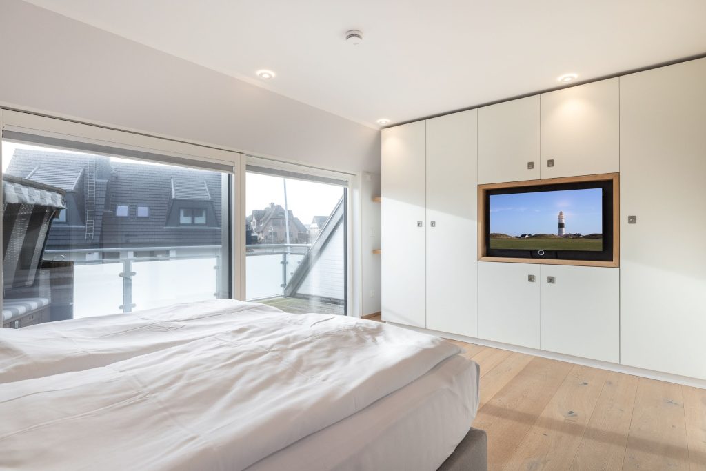 komfortables Bett und Schrankfernseher in Ferienwohnung auf Sylt